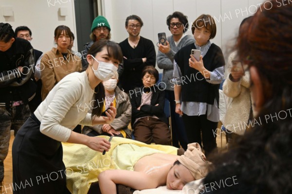 参加者を前に背中のシェービングを行いながら説明する講師