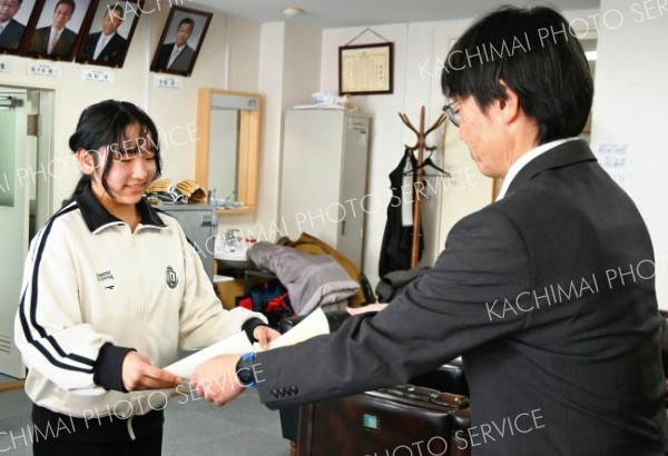 表彰状を受け取る