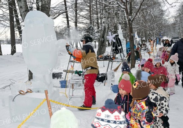 明日の開幕を前に、氷彫刻作品を完成を目指し、急ピッチで作業を進める参加者（２９日午前１０時半ごろ。帯広市緑ヶ丘公園で。金野和彦撮影）