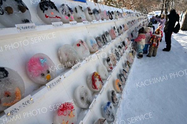 ずらりと並んだ氷のお面を鑑賞する子どもたち（３０日午前１１時ごろ、須貝拓也撮影）