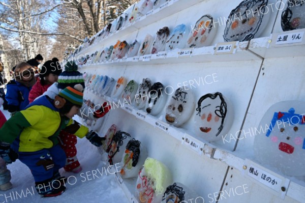 ずらりと並んだ氷のお面を鑑賞する子どもたち（３０日午前１１時ごろ、須貝拓也撮影）