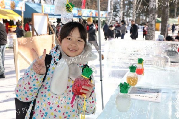 氷に囲まれた帯広ＹＥＧの「アイスＢＡＲ」で”光るボトル”を手にする子ども（１日、平栗玲香通信員撮影）