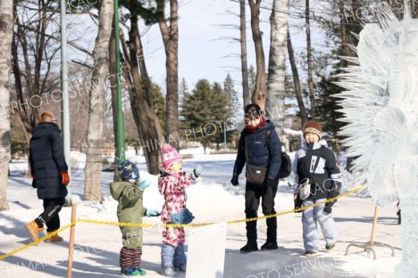 「第２０回全国氷彫刻展冬季帯広大会」の作品を鑑賞する子どもたち（１日午前１０時１５分ごろ、平栗玲香通信員撮影）