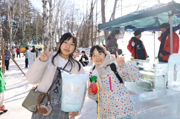 氷に囲まれた帯広ＹＥＧの「アイスＢＡＲ」で”光るボトル”などを手にする子どもたち（１日、平栗玲香通信員撮影）