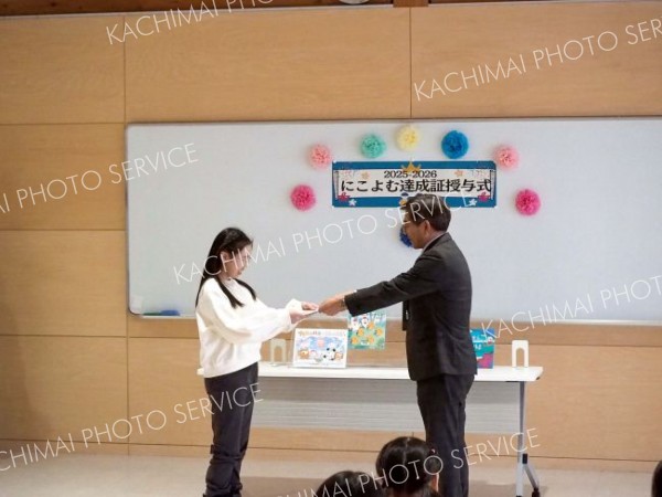 達成証を受け取る児童