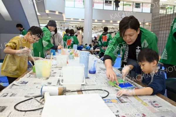 職人の説明を受けながら真剣な表情で手を動かす子ども