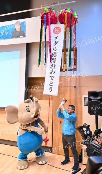 高木選手が女子１０００メートルで銅メダルを獲得し、くす玉を割る幕別町のマスコットキャラクター「パオくん」（１０日、塩原真撮影）