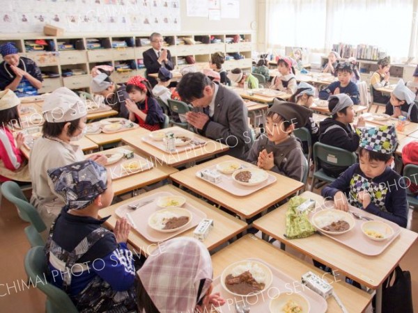 町議会総務常任委員会の委員と一緒に「広尾産とうだいつぶカレー」を味わう子どもたち