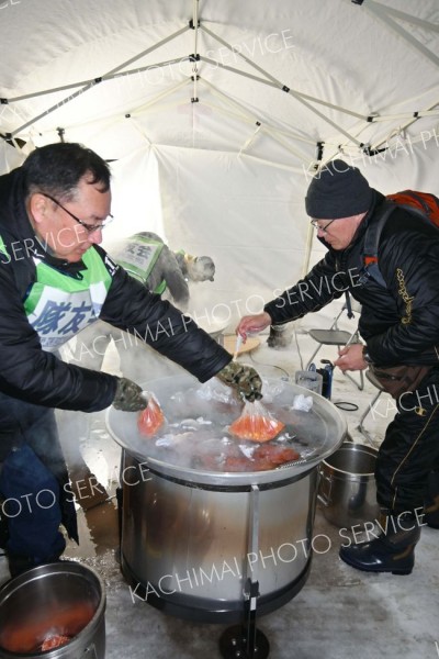 屋外のテントで炊き出し訓練に当たる参加者ら