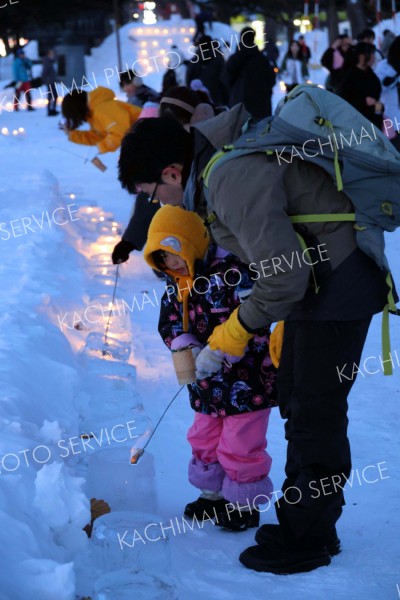 午後５時から始まった点灯式。来場者には種火が実行委員会から配布され、会場にある３０００個のキャンドルに次々と火をともした