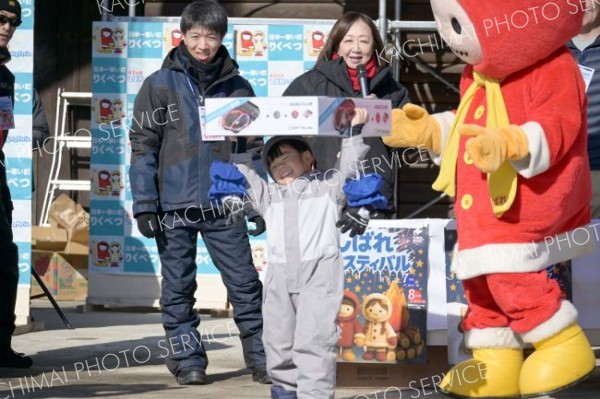 <strong>高々と</strong><br>　ゲームやお菓子が当たるこども抽選会は、親も含めて大盛り上がり。自分の番号が呼ばれると、足早にステージへ駆け上がる子どもたちが印象的だった