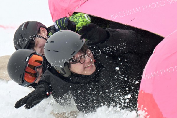 スピード注意！―。予想を超えるソリの速さにおバランスを崩す出場者。雪しぶきが気持ちいい