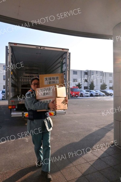 到着した支援物資を避難所に運び込む職員ら