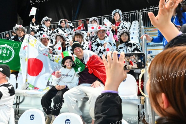 ウシ柄軍団大人気―。ミラノ・コルティナ五輪のスピードスケート会場で、堀川桃香選手（大樹町出身）の応援に駆けつけた家族や関係者らが身にまとう、ウシ柄模様のハットとジャケット姿が観戦客や外国人メディアから注目を浴びた。イタリアの親子も五輪の記念に１枚（現地時間２月１７日。金野和彦撮影）