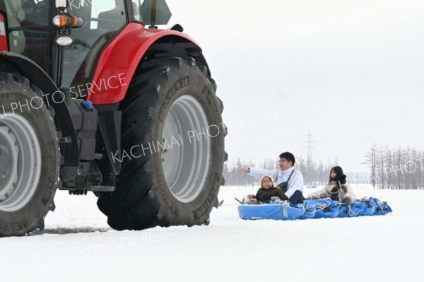 トラクターが引っ張るチューブを楽しむ来場者