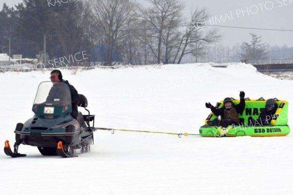 スノーモービルが引っ張る「バナナボート」に歓声をあげる子ども