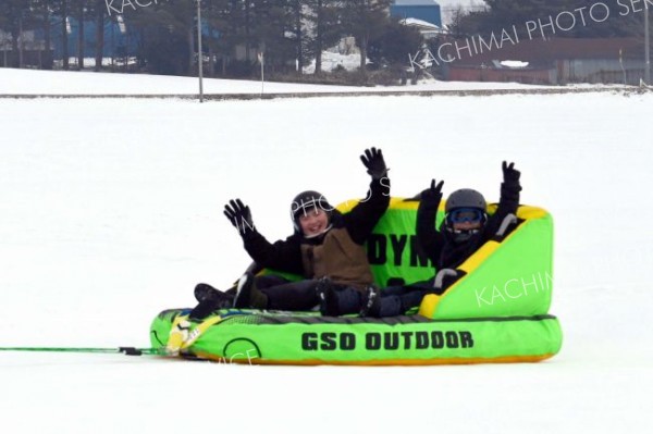 スノーモービルが引っ張る「バナナボート」に歓声をあげる子ども