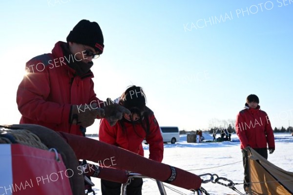生徒らと共に熱気球の準備をする、白戸教諭（８日、上士幌町航空公園で。須貝拓也撮影）