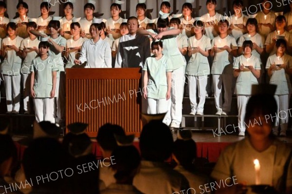 上級生から看護帽を着けてもらう１年生