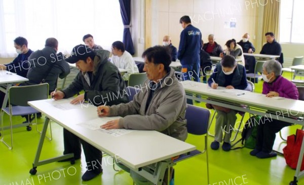 避難者カードに記入する参加者たち