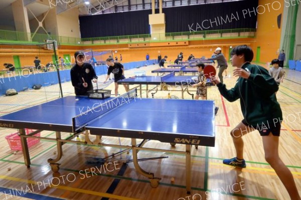 駒大苫小牧高の卓球部員と練習に励む上士幌中の生徒（右）