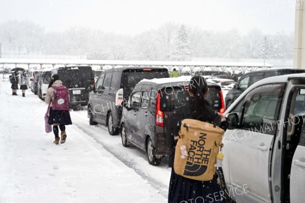 雪が降る中、保護者の送迎で受験会場へと向かう受験生（４日午前７時５０分ごろ、帯広緑陽高校。須貝拓也撮影）