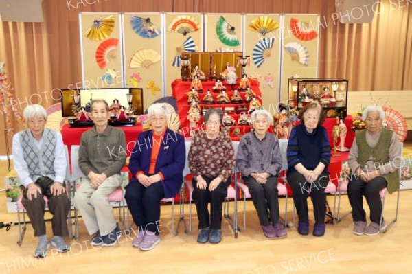 華やかなひな人形を前に並ぶ利用者ら