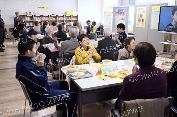 給食を通して地域住民と交流する児童生徒ら