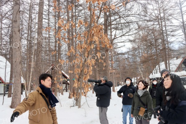 参加者らにシマエナガをはじめ施設で見られる野鳥について解説する宮本さん（左）