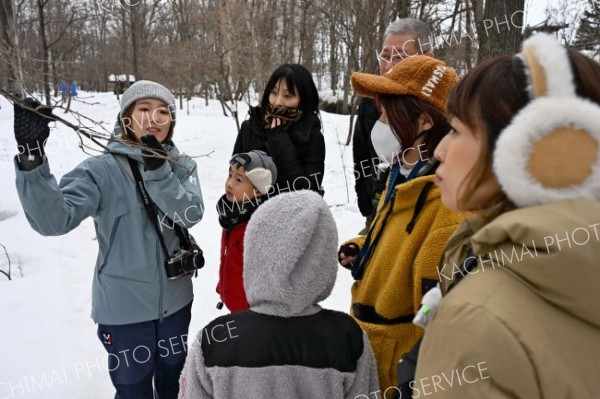 枝の先についた冬芽や葉痕の解説をする野表さん（左）と、耳を傾ける参加者ら