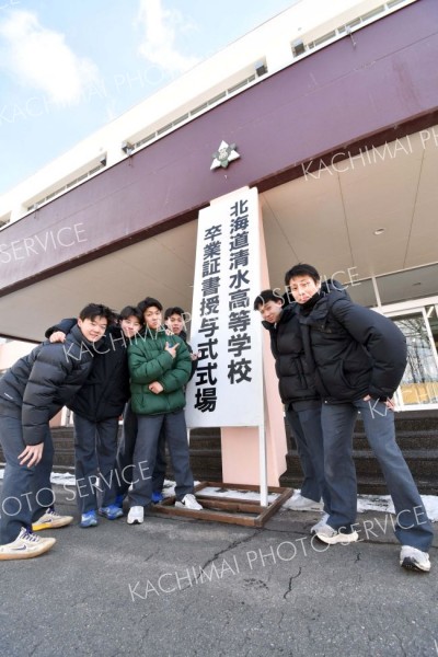 思い出の詰まった校舎の前で記念撮影する卒業生（清水、吉原慧撮影）