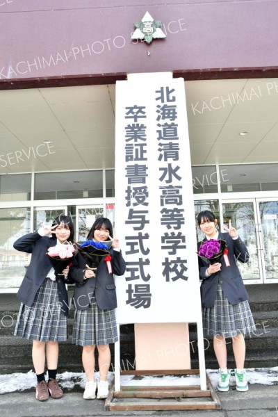 思い出の詰まった校舎の前で記念撮影する卒業生（清水、吉原慧撮影）