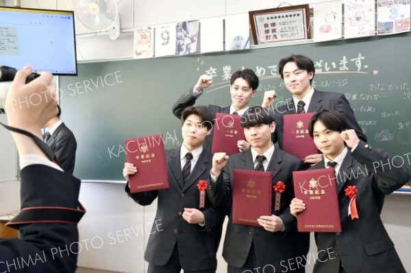 思い出の詰まった教室で卒業証書を手にクラスメートと記念撮影する卒業生（清水、吉原慧撮影）