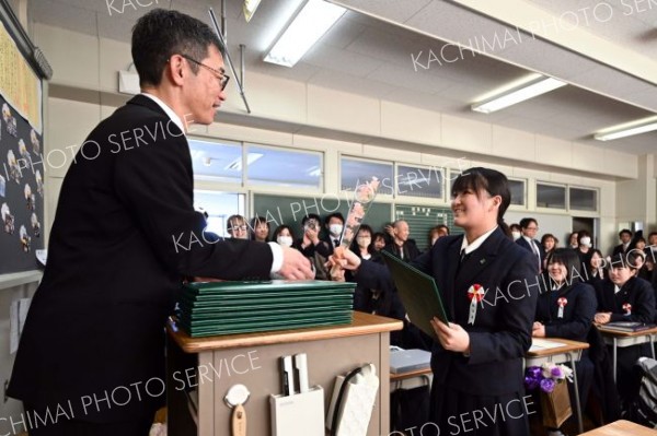 担任の柴崎教諭から花を受け取る卒業生（帯広南商業、須貝拓也撮影）