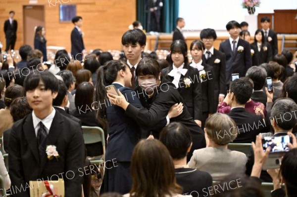 おめでとう―。わが子の卒業を喜び、思わずハグをする保護者も（帯広柏葉、金野和彦撮影）