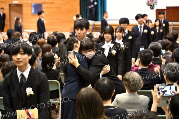 おめでとうのハグ―。わが子と抱き合って卒業を喜ぶ保護者（帯広柏葉、金野和彦撮影）