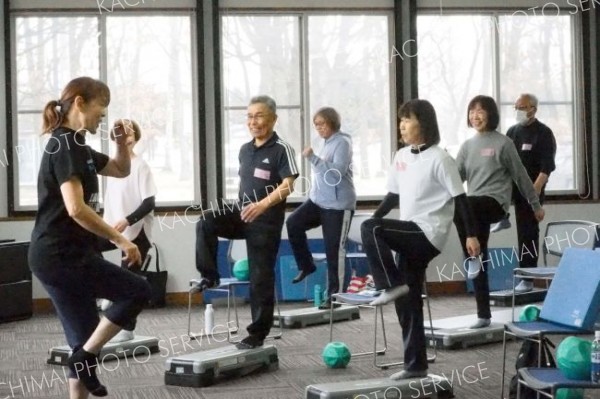 踏み台を使用してトレーニングする参加者